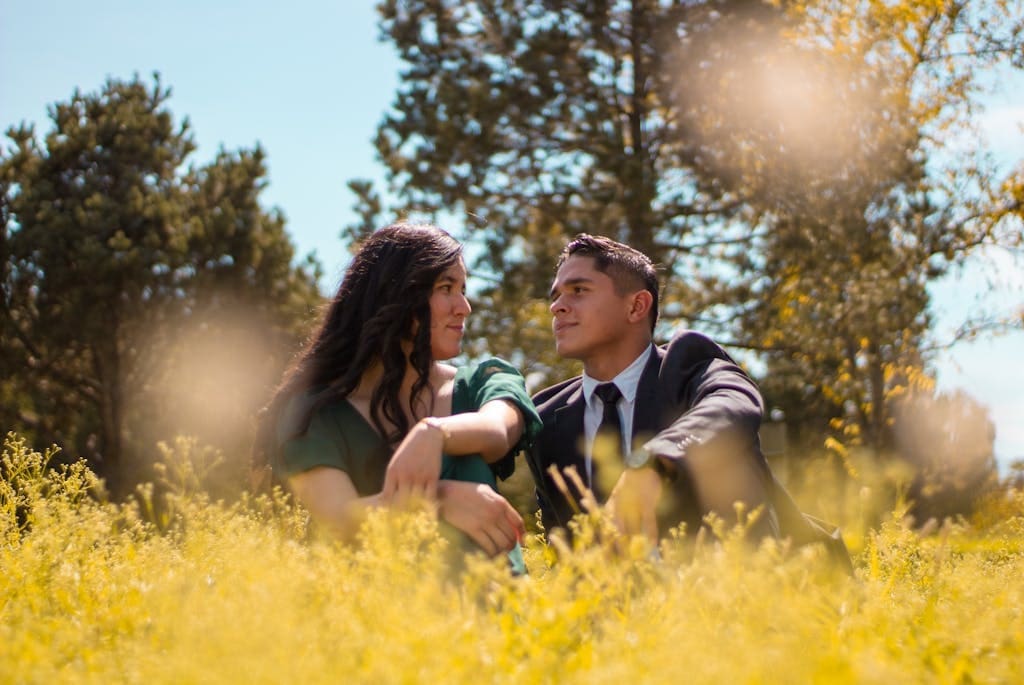 Young Couple Sitting Together in a Yellow Meadow